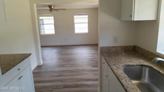 an empty room with wooden floor cabinets and a kitchen counter top