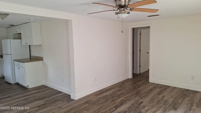 a view of a room with wooden floor and white walls