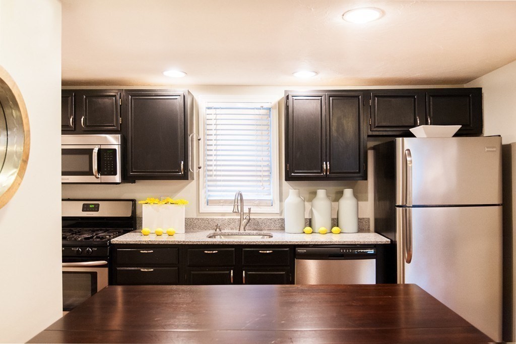 224 West Sixth Street, Unit 2 Boston, MA 02127 - Photo 8 of 18 a kitchen with stainless steel appliances kitchen island granite countertop a refrigerator a stove a sink and a microwave