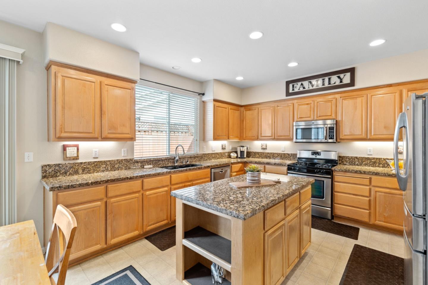 8975 Del Rio Circle Gilroy, CA 95020 - Photo 12 of 24 a kitchen with granite countertop kitchen island sink stove and refrigerator