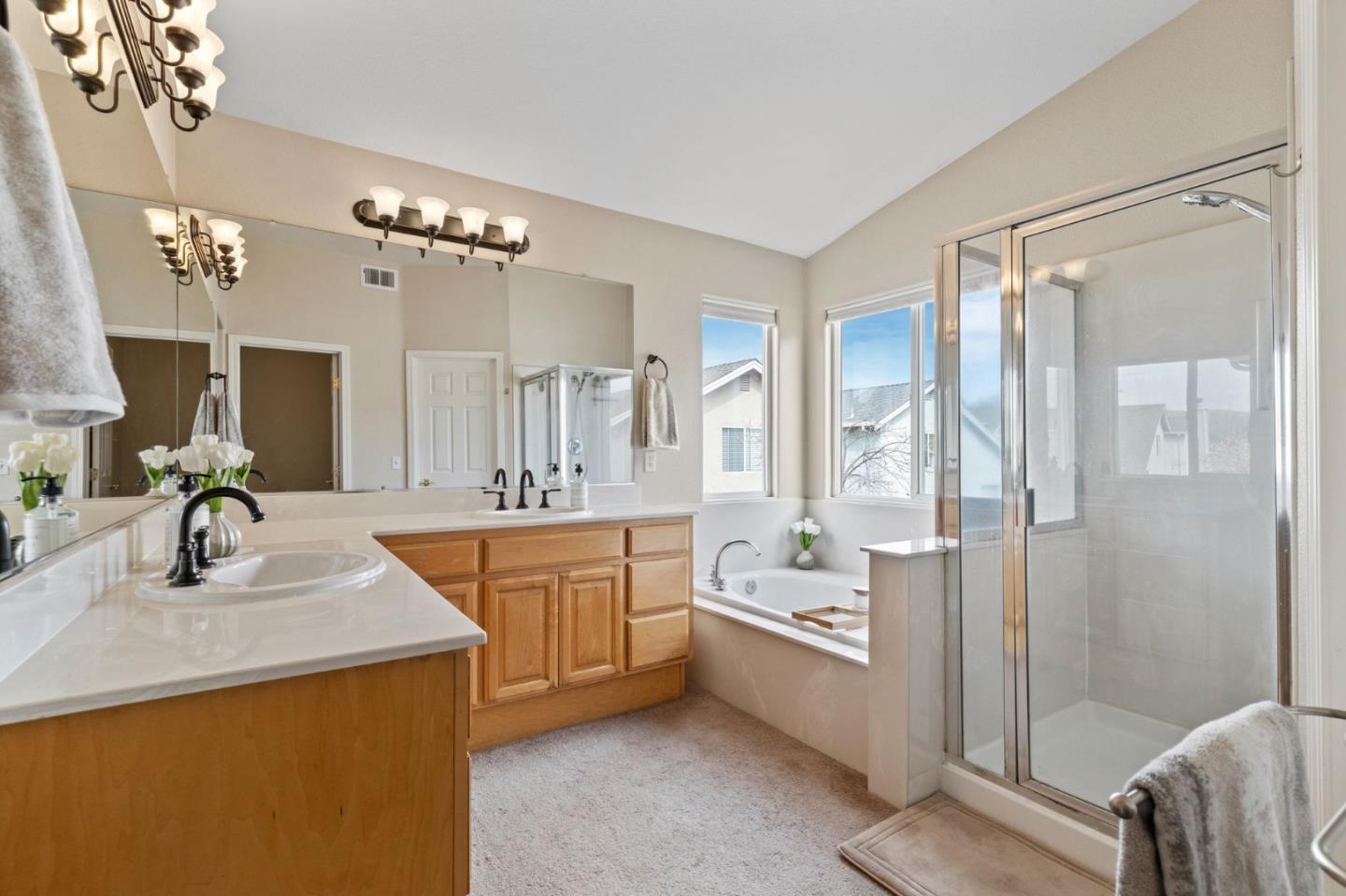 8975 Del Rio Circle Gilroy, CA 95020 - Photo 16 of 24 a spacious bathroom with a double vanity sink a mirror a bathtub and shower