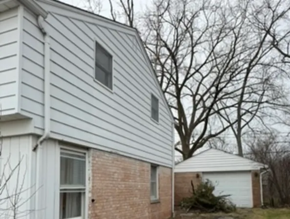 a view of a white house with a large tree