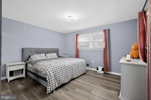 a bedroom with a bed and a flat tv screen on the dresser