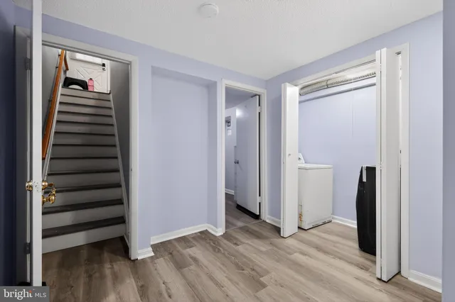 a view of an empty room with wooden floor and entryway