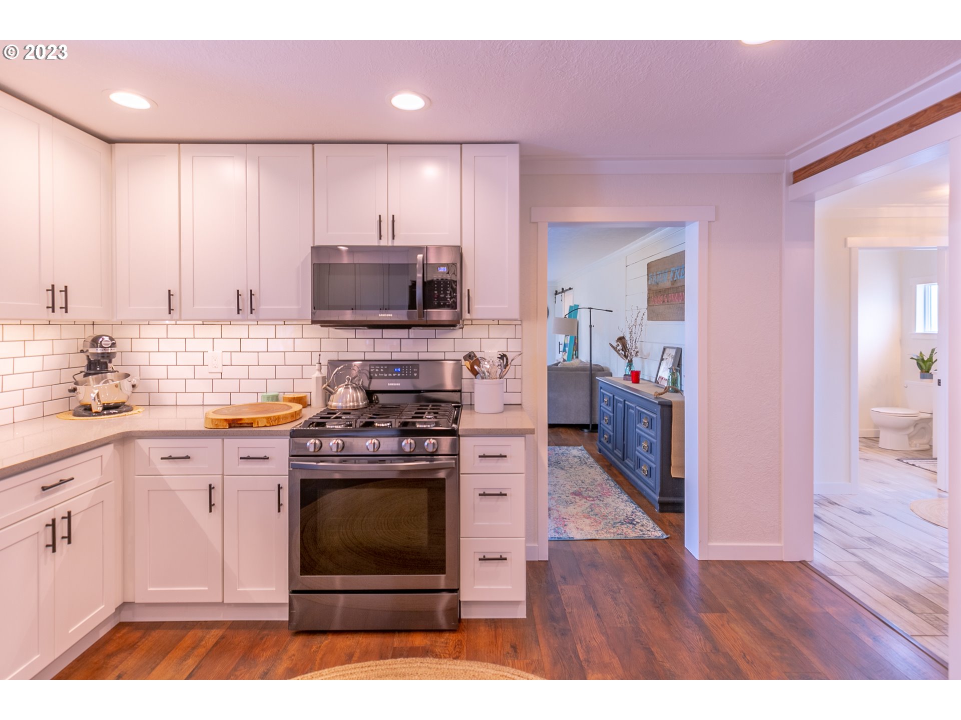 438 West Mary Street Lebanon, OR 97355 - Photo 3 of 33 a kitchen with stainless steel appliances a stove a sink cabinets and a wooden floor