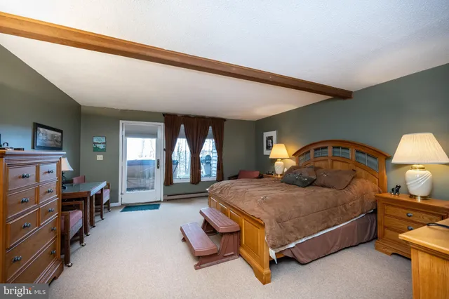 a bedroom with a bed and dresser with mirror