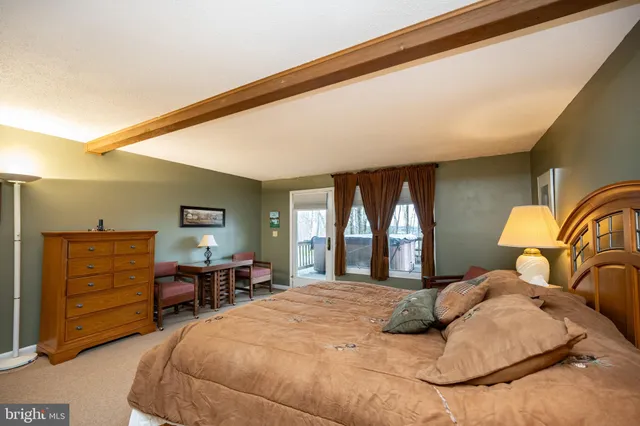 a bedroom with a bed and dresser with mirror