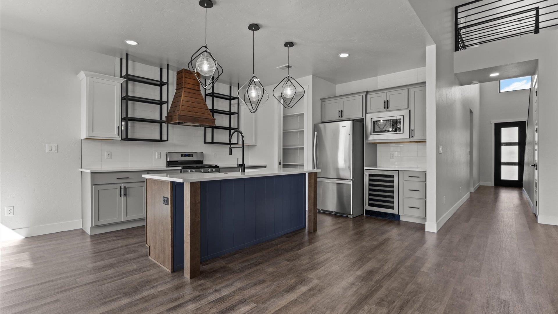 745 Fairhaven Road Palisade, CO 81526 - Photo 11 of 33 a kitchen with stainless steel appliances kitchen island a refrigerator and a wooden floor
