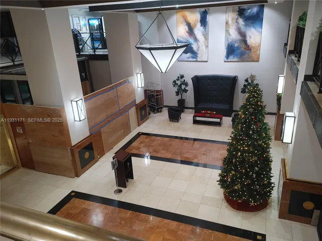 a living room with couches and kitchen view with wooden floor