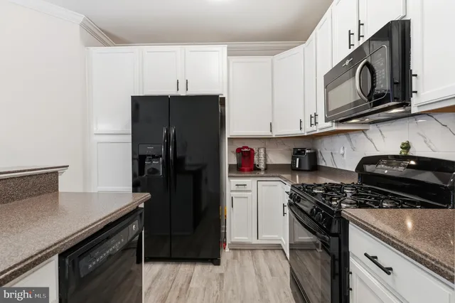 a kitchen with a refrigerator and a stove top oven