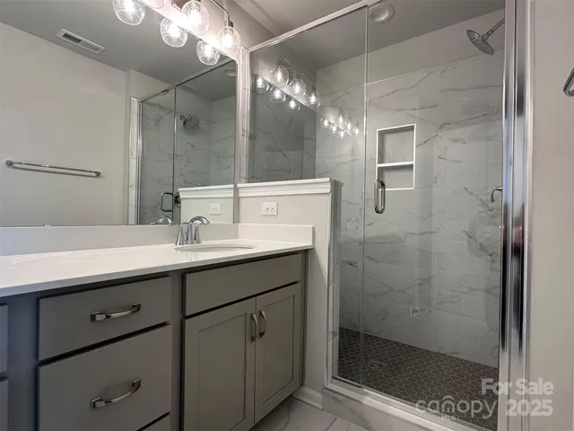 a bathroom with a shower sink and mirror