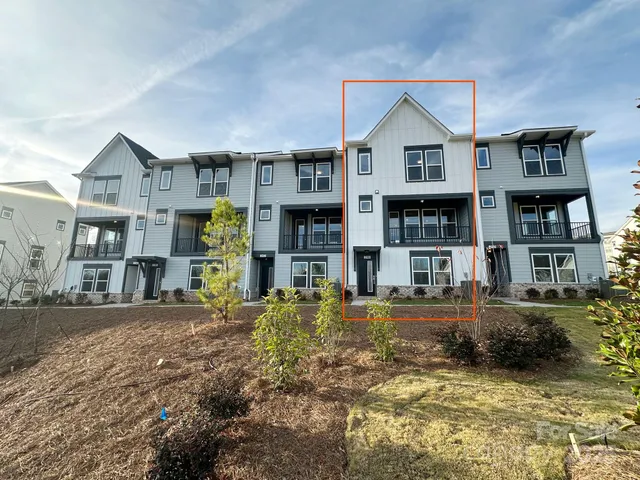 a front view of a residential apartment building with a yard