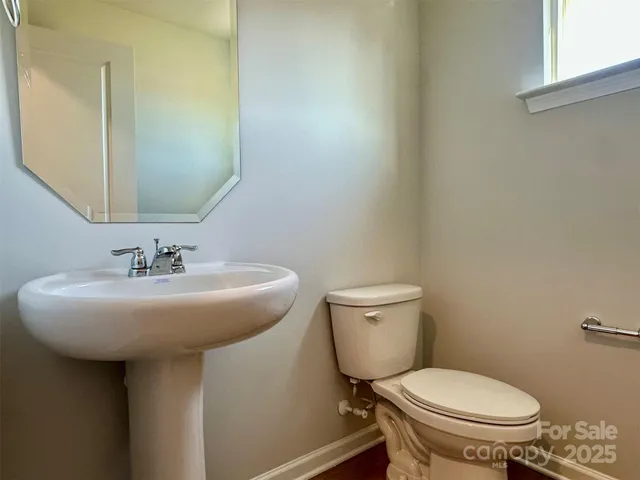 a bathroom with a sink toilet and a mirror
