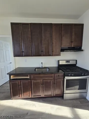 a kitchen with wooden cabinets and a stove top oven