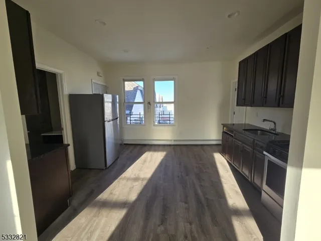 a view of kitchen with refrigerator stove and wooden floor