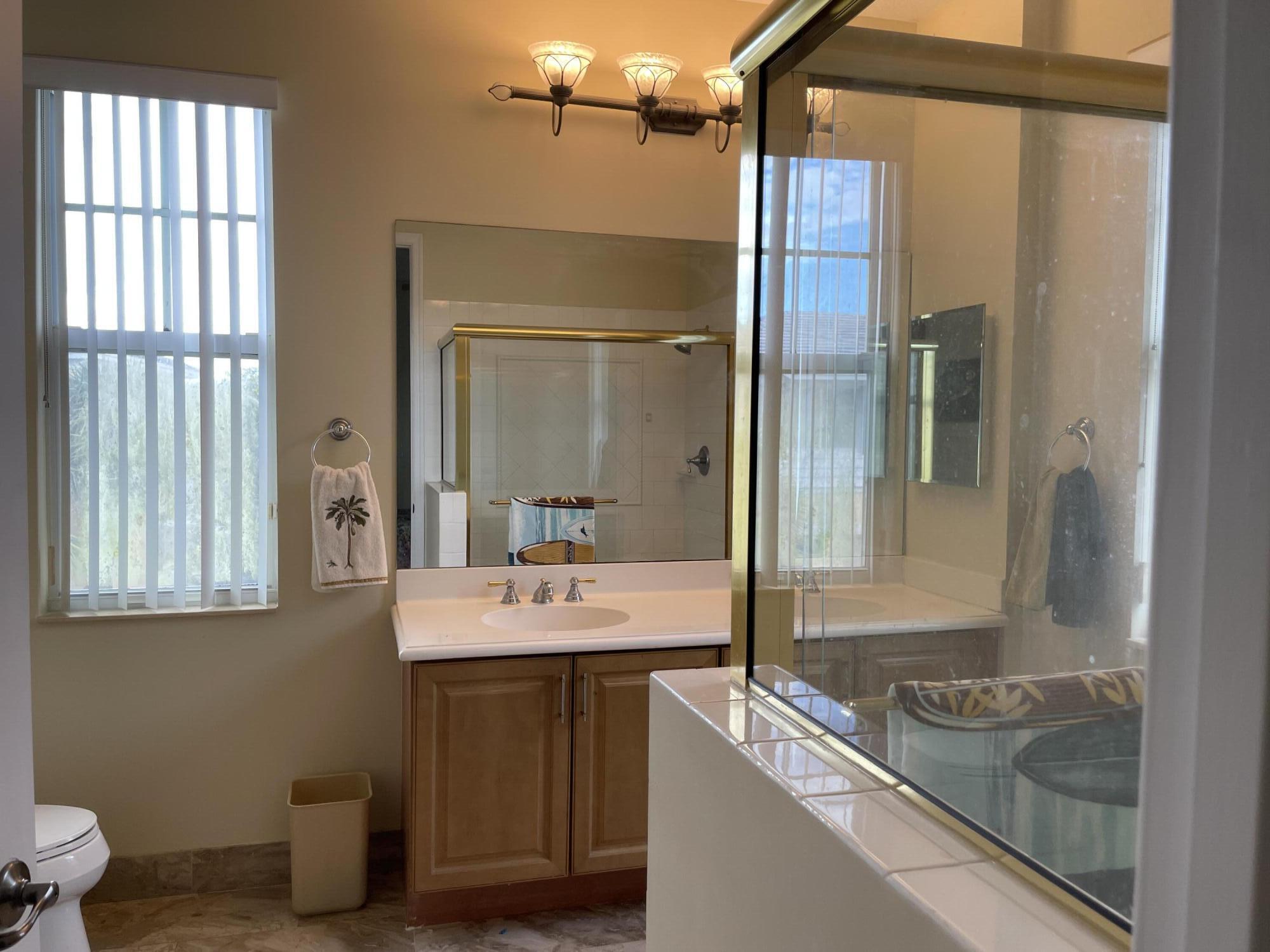 552 North West 39th Circle Boca Raton, FL 33431 - Photo 24 of 33 a en suite bathroom with a granite countertop sink and a mirror