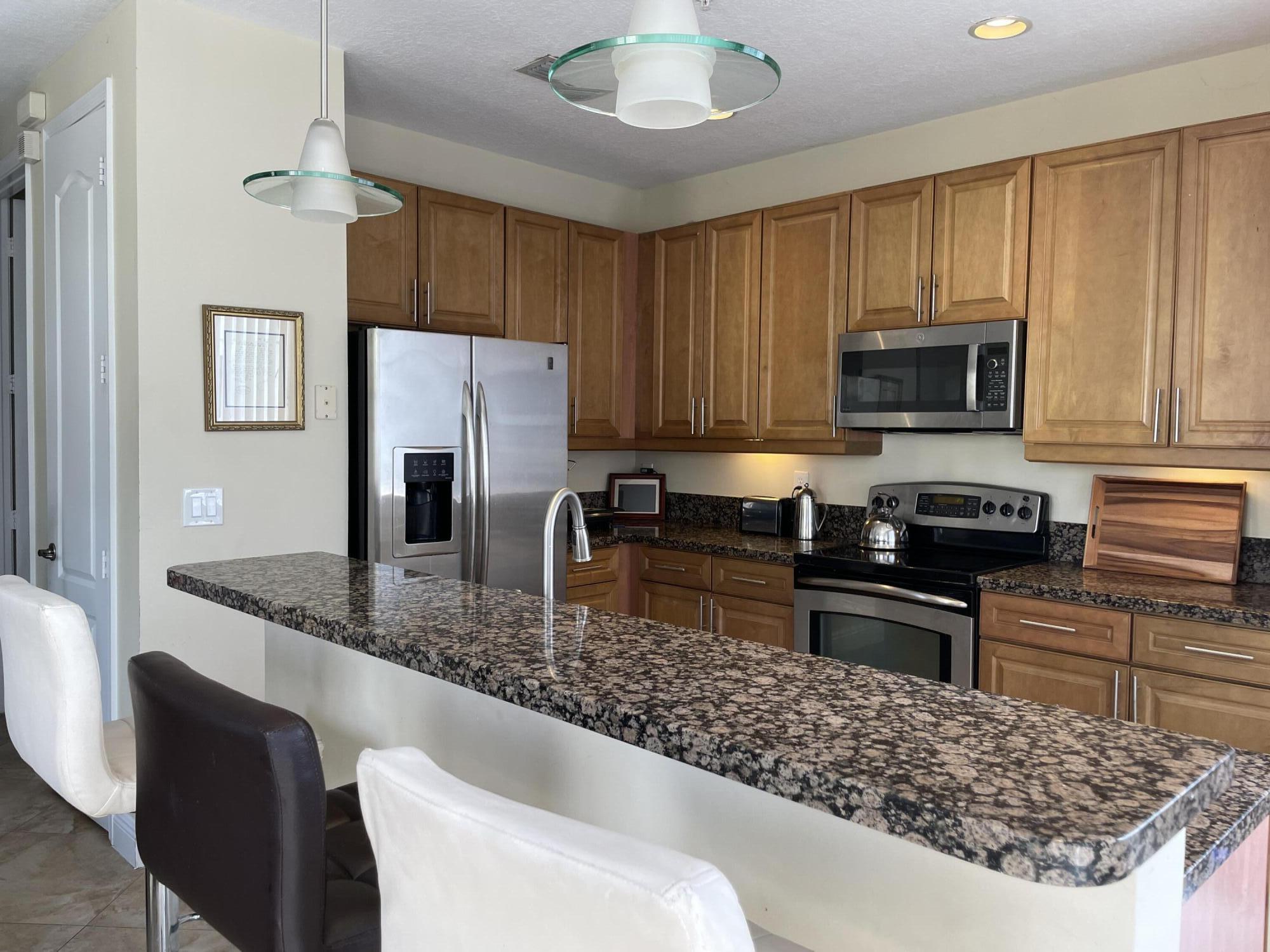 552 North West 39th Circle Boca Raton, FL 33431 - Photo 5 of 33 a kitchen with stainless steel appliances granite countertop a stove a sink a microwave a refrigerator and cabinets