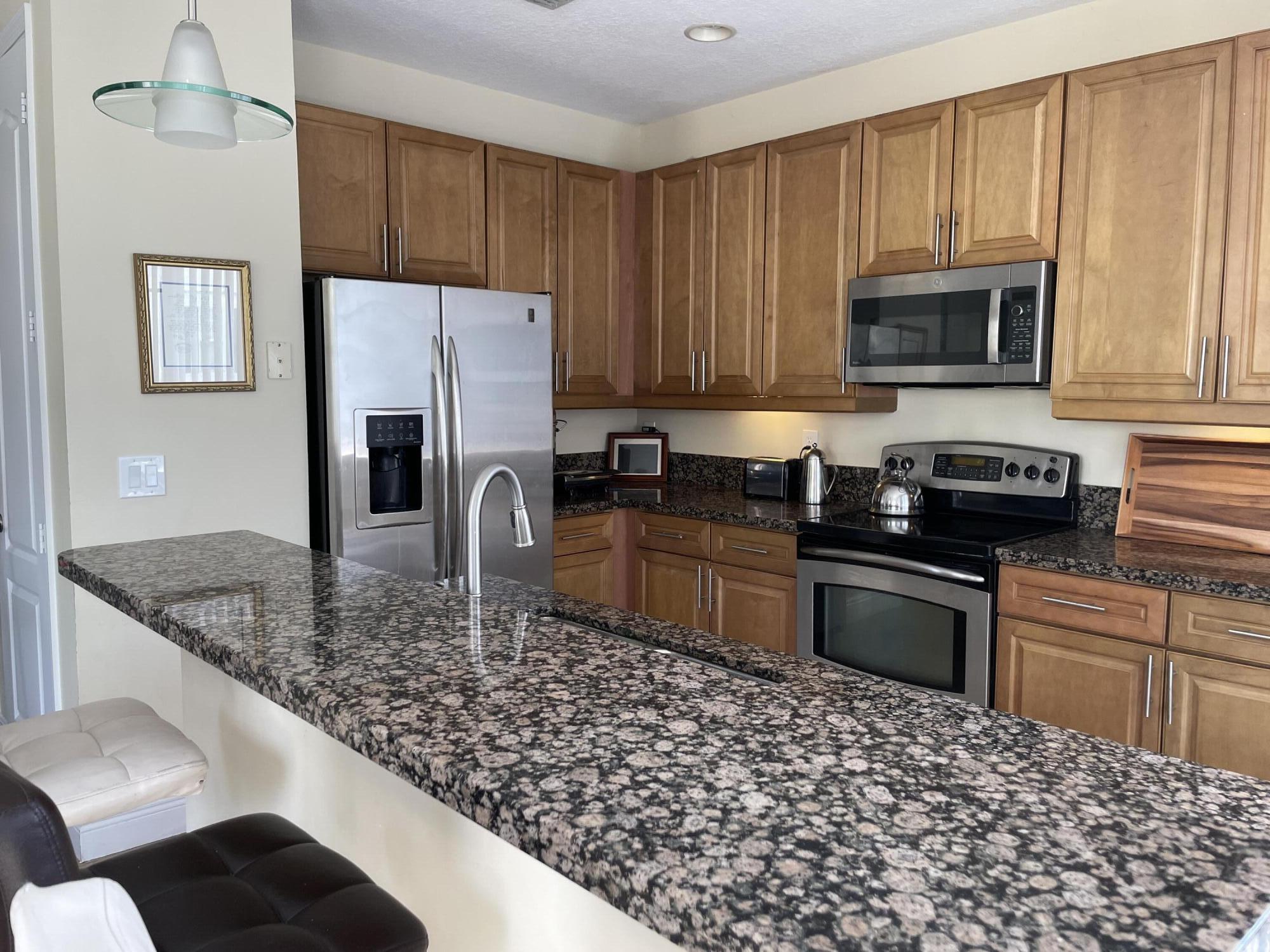 552 North West 39th Circle Boca Raton, FL 33431 - Photo 6 of 33 a kitchen with stainless steel appliances granite countertop a sink refrigerator and microwave