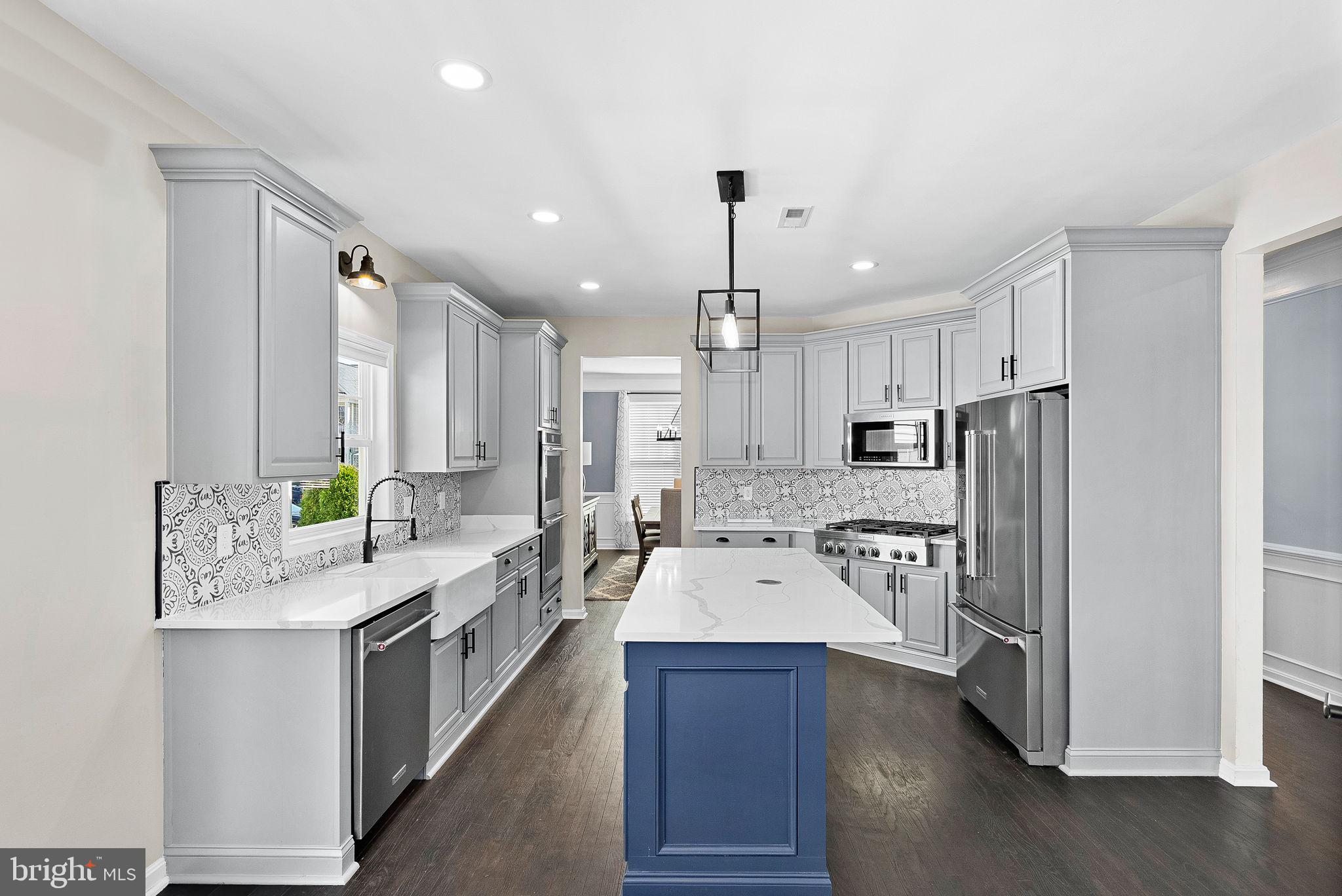 23388 Minerva Drive Brambleton, VA 20148 - Photo 12 of 57 a large kitchen with a counter space a sink appliances and cabinets