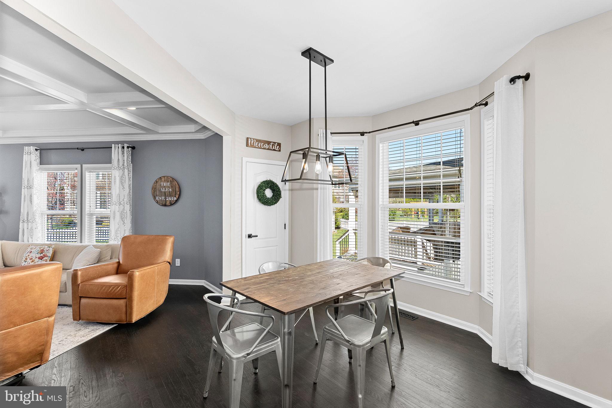 23388 Minerva Drive Brambleton, VA 20148 - Photo 15 of 57 a dining room with furniture a chandelier and wooden floor