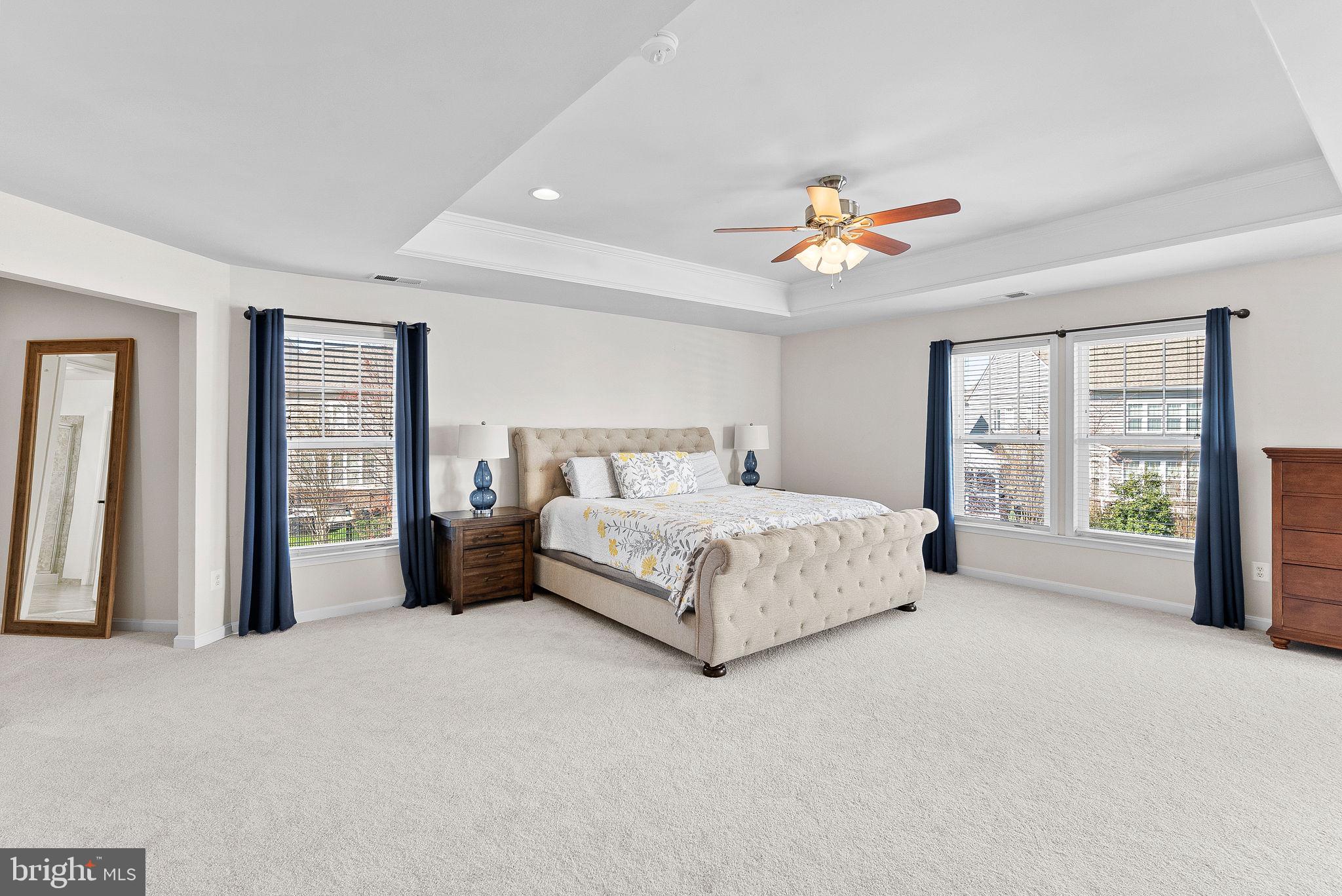 23388 Minerva Drive Brambleton, VA 20148 - Photo 25 of 57 a spacious bedroom with a large bed a chandelier and windows