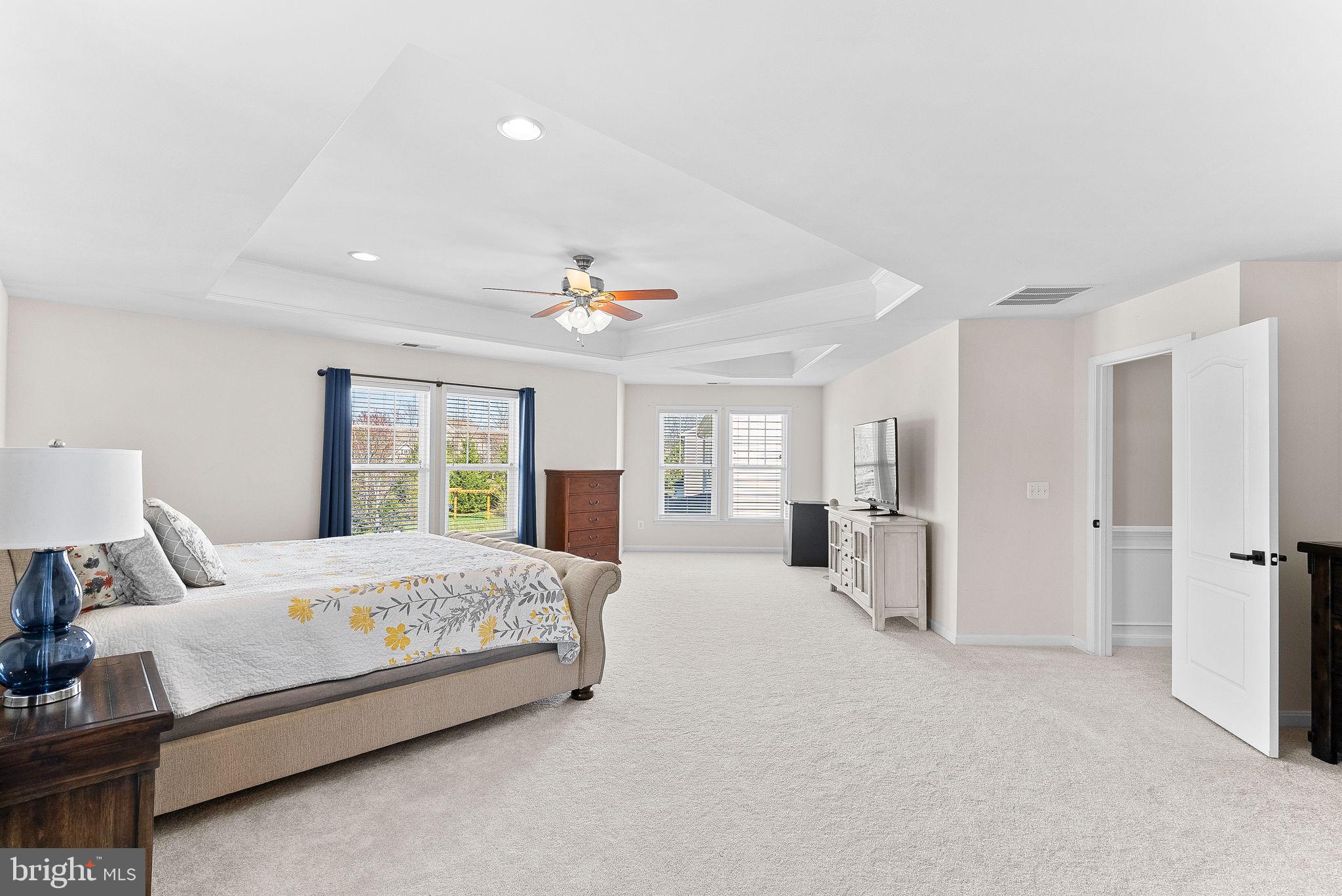 23388 Minerva Drive Brambleton, VA 20148 - Photo 26 of 57 a bedroom with a large bed and a chandelier