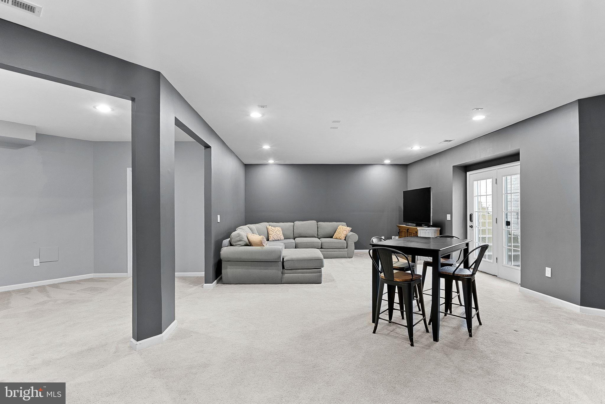 23388 Minerva Drive Brambleton, VA 20148 - Photo 41 of 57 a living room with furniture a flat screen tv and a window