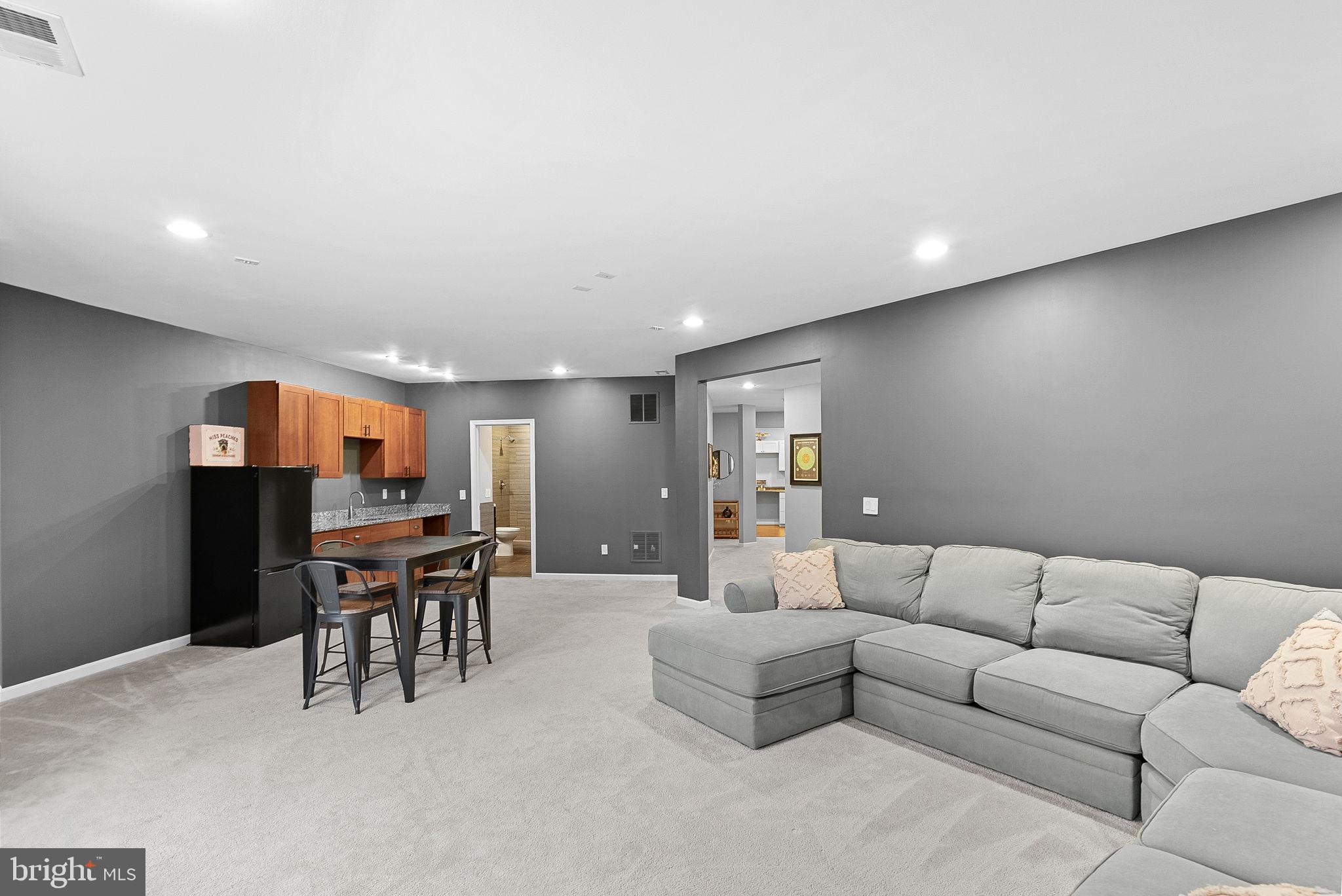 23388 Minerva Drive Brambleton, VA 20148 - Photo 44 of 57 a living room with furniture a dining table and a piano