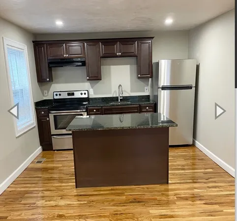 a kitchen with stainless steel appliances granite countertop a stove a refrigerator and a microwave