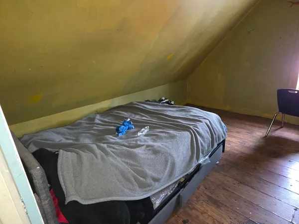 a bed sitting in a bedroom next to a window