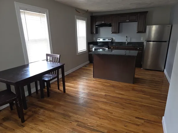 a kitchen with stainless steel appliances granite countertop a sink stove refrigerator and a window