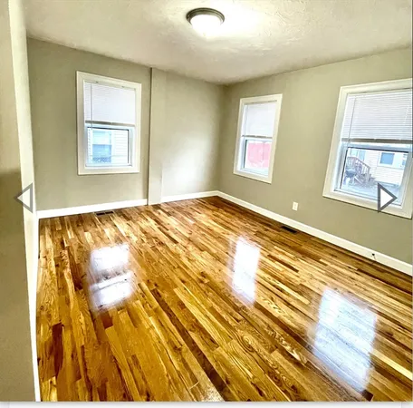 a bedroom with wooden floor and window