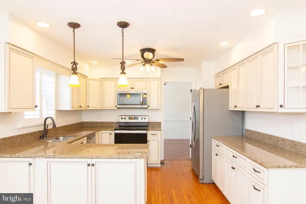 a kitchen with stainless steel appliances granite countertop a sink a stove and a refrigerator