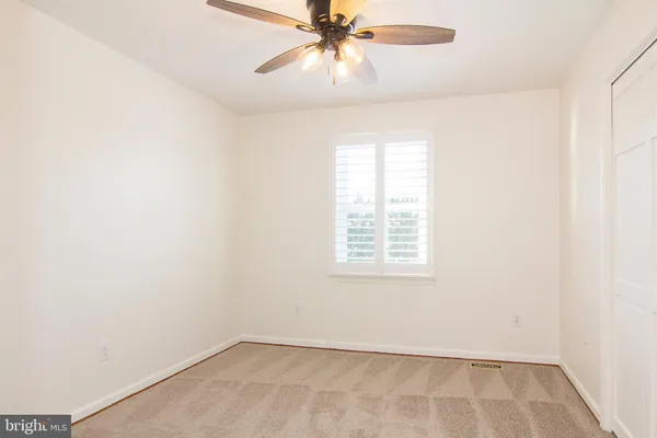 an empty room with a window and a ceiling fan