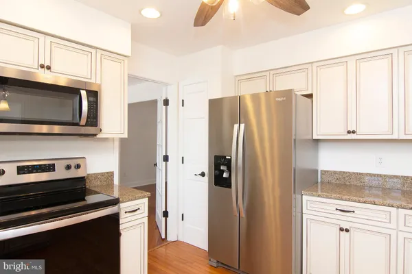 a kitchen with stainless steel appliances granite countertop a refrigerator and a stove top oven