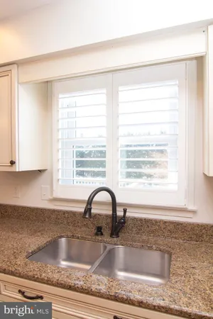 a kitchen with granite countertop a sink and cabinets
