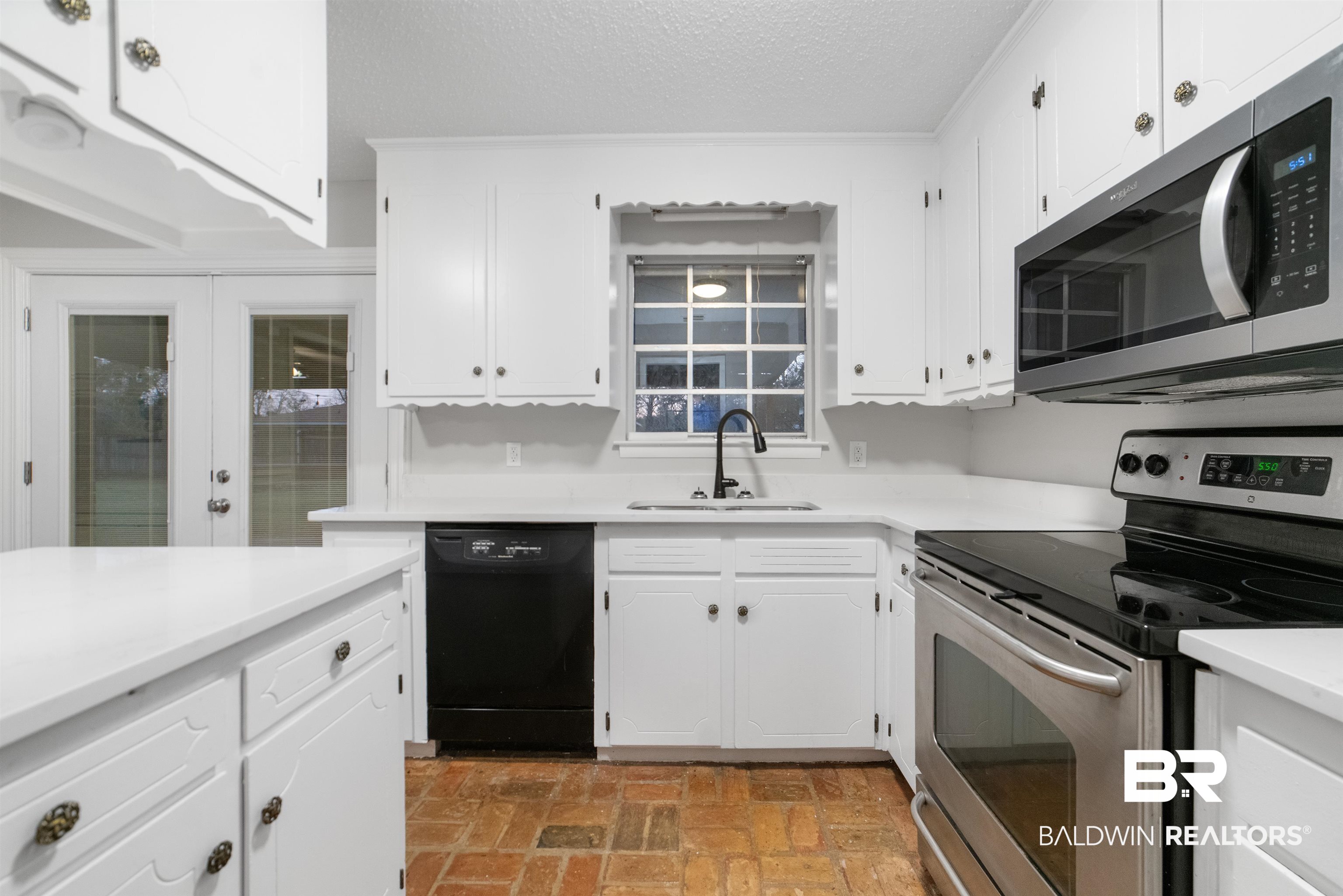 11833 Old Moffat Road Wilmer, AL 36587 - Photo 6 of 23 Kitchen with white cabinetry, stainless steel appliances, a sink, and light countertops