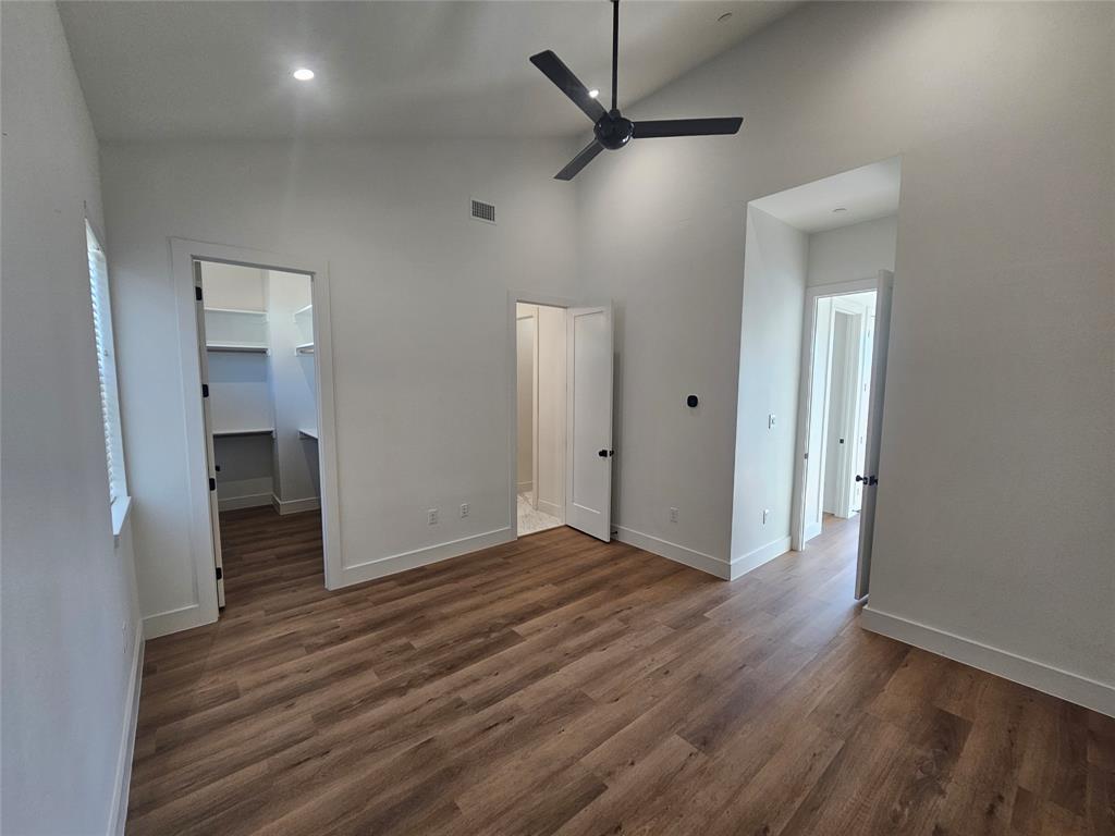 2139 Mail Avenue, Unit 101 Dallas, TX 75235 - Photo 19 of 21 Master bedroom featuring a walk in closet, ceiling fan with vaulted ceiling and ensuite bathroom