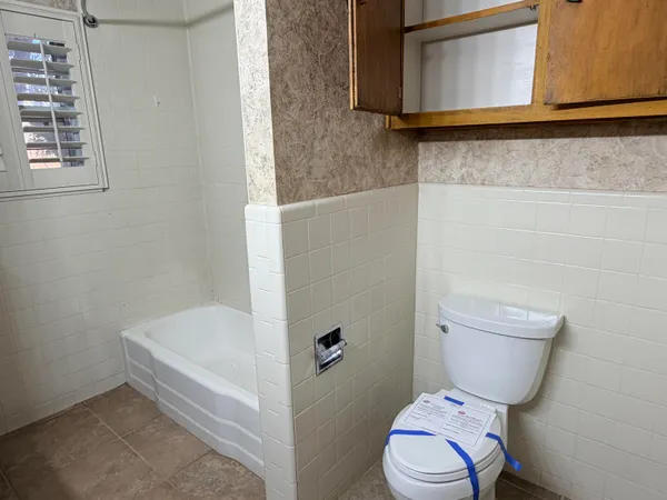 a bathroom with a granite countertop toilet and a sink