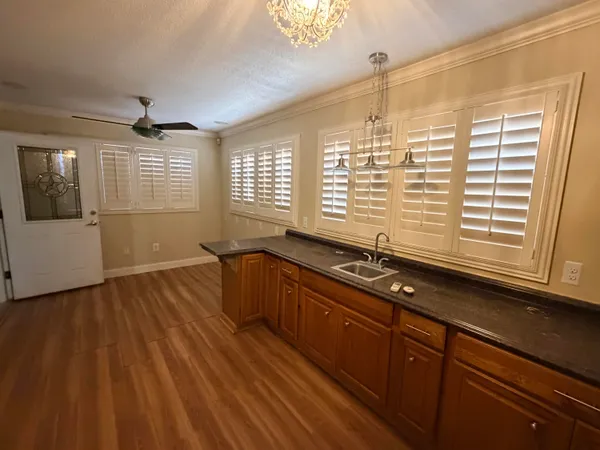 a kitchen with wooden floors and large windows