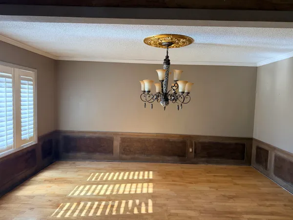 a view of empty room with a window and chandelier