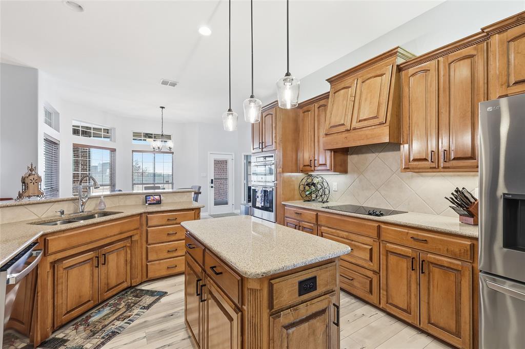 7915 Stone Ridge Drive Northlake, TX 76247 - Photo 12 of 40 a kitchen with granite countertop a sink a counter space appliances and cabinets