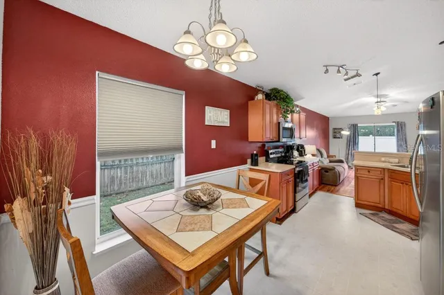 a living room with furniture a flat screen tv and kitchen view