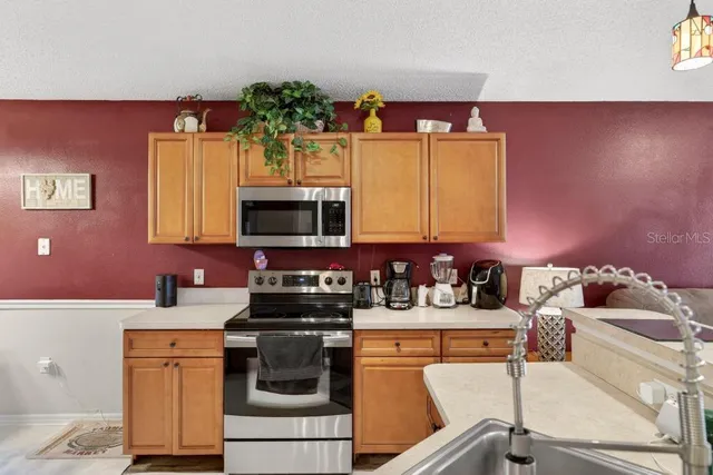 a living room with furniture kitchen view and a wooden floor