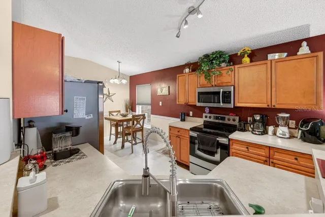 a living room with furniture kitchen view and a wooden floor