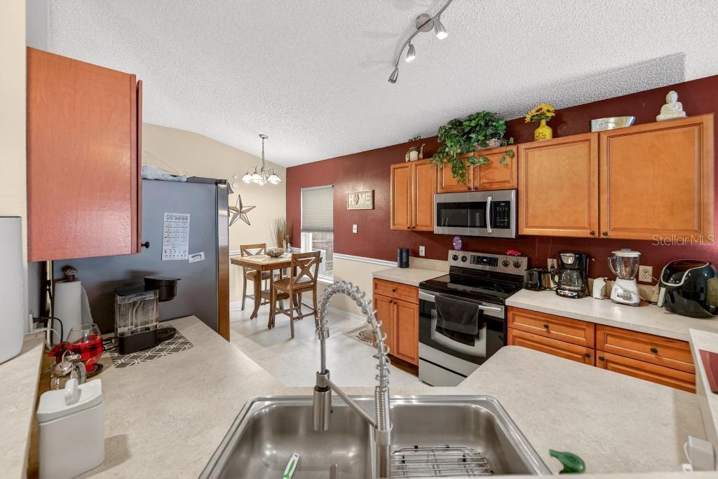 1332 Honey Road Apopka, FL 32712 - Photo 19 of 59 a kitchen that has a lot of cabinets a sink and appliances in it