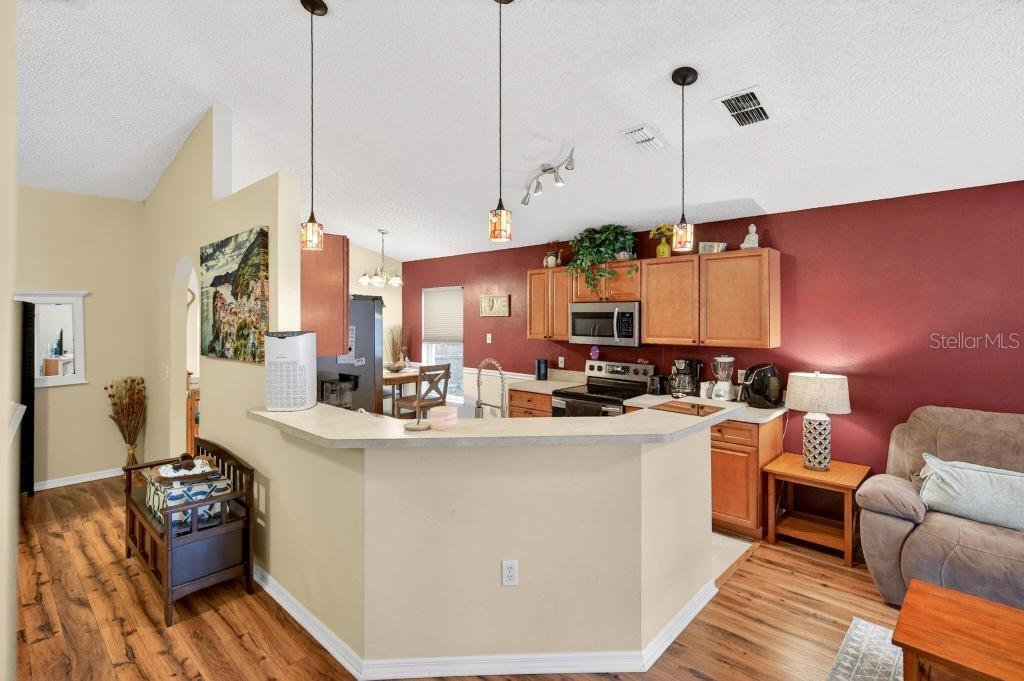 1332 Honey Road Apopka, FL 32712 - Photo 20 of 59 a view of a kitchen with kitchen island stainless steel appliances a stove a sink and living room view