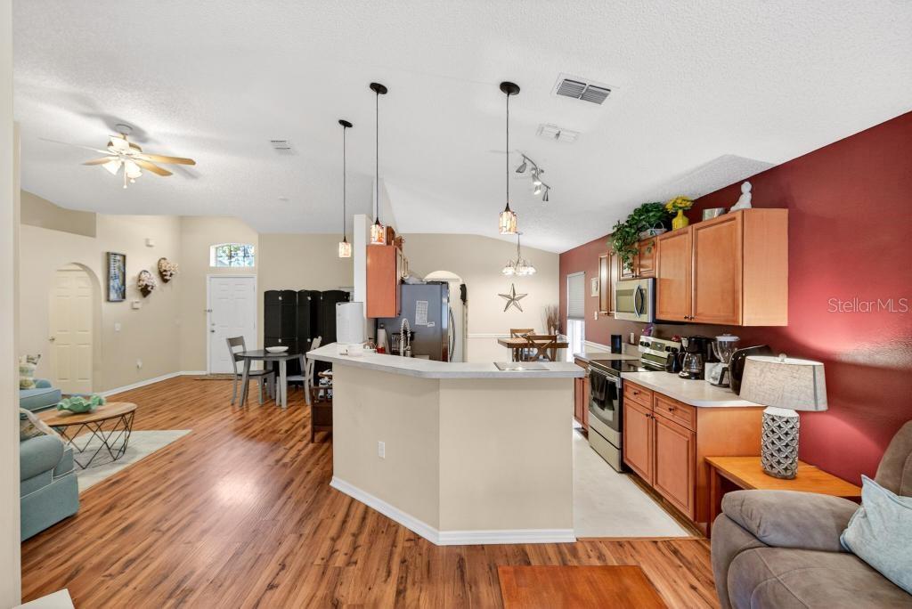 1332 Honey Road Apopka, FL 32712 - Photo 21 of 59 a living room with furniture kitchen view and a wooden floor