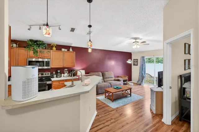 a living room with furniture a flat screen tv and a floor to ceiling window