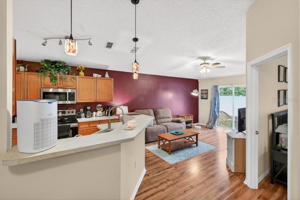 1332 Honey Road Apopka, FL 32712 - Photo 22 of 59 a living room with furniture kitchen view and a wooden floor